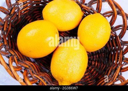 Four lemons in a wicker basket. Andalucía, Spain, Europe Stock Photo