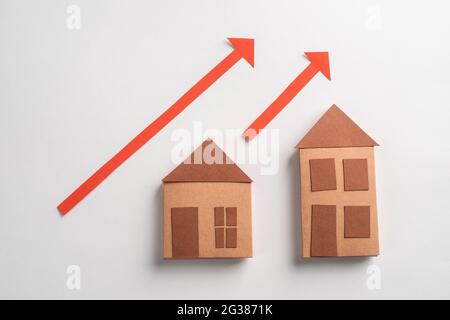3d paper houses and red arrows pointing up on white background Stock Photo