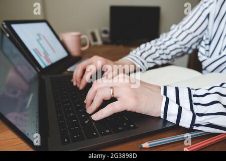 A married young woman who works by following the stock markets from her home. Stock Photo