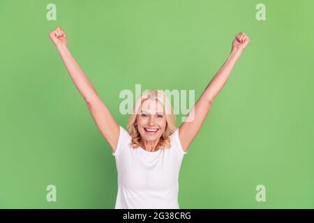 Photo portrait senior woman overjoyed happy gesturing like winner isolated pastel green color background Stock Photo