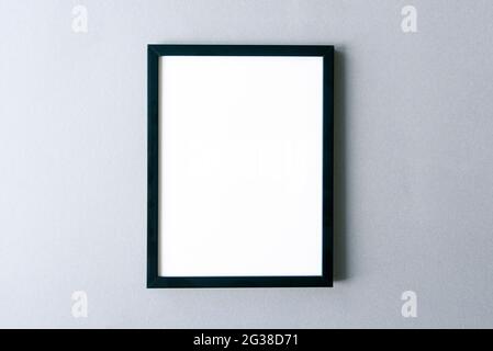 Frame mockup, black photo frame with blank surface on gray wall. Space for text. Stock Photo