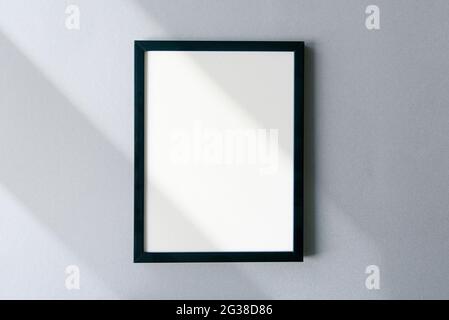 Blank photo frame mockup with shadows and sunlight on surface. Template with space for text. Stock Photo