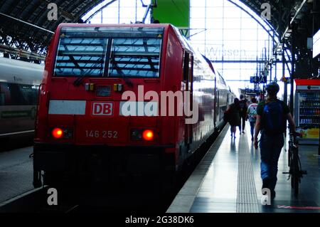 FRANKFURT, GERMANY - Jun 10, 2021: Travellers rush to the train at Frankfurt Central Station. A backlit shot. Stock Photo