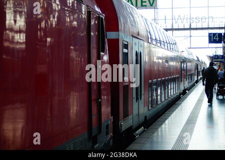 FRANKFURT, GERMANY - Jun 10, 2021: A train in the backlight on the platform at Frankfurt Central Station. Passengers hurry to the train. Reflection an Stock Photo