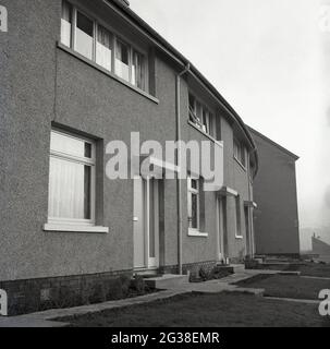 1966, historical, exterior view of recently built local authority housing, Hamilton Terrace, Fife, Scotland.  With a concrete or cement  exterior render, these properties were built in the stark, so-called 'brutalist' architectural style, popular in this era. On the doorstep of one of the houses, two pints of milk. Stock Photo