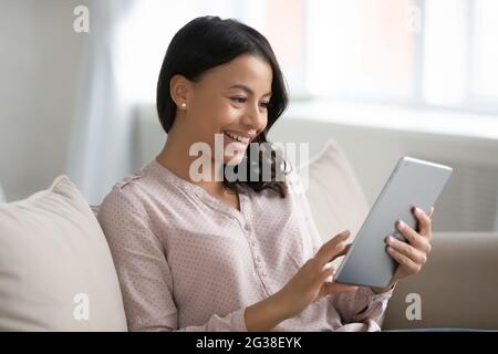 Happy mixed raced woman using tablet for video call Stock Photo