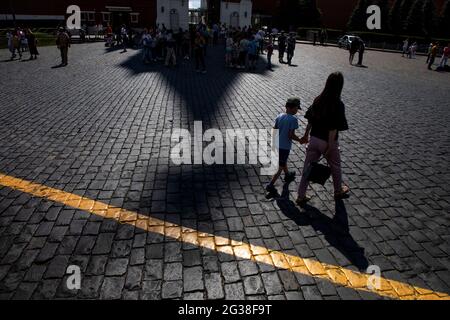 Moscow, Russia. 14th of June, 2021 People walk on Red Square on a hot summer afternoon near Spasskaya tower of the Moscow's Kremlin Stock Photo