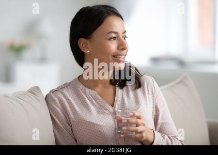 Happy pretty young mixed race woman drinking glass of water Stock Photo