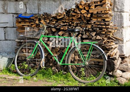 Green bike pinned to the fence close up Stock Photo
