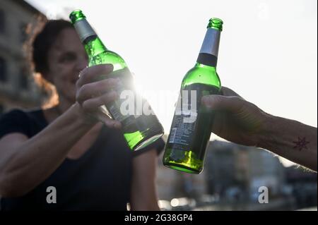 Berlin, Germany. 14th June, 2021. ILLUSTRATION - Two people sit on the Iron Bridge at the Lustgarten in warm weather and toast with beer in the evening sun. Credit: Kira Hofmann/dpa-Zentralbild/dpa/Alamy Live News Stock Photo