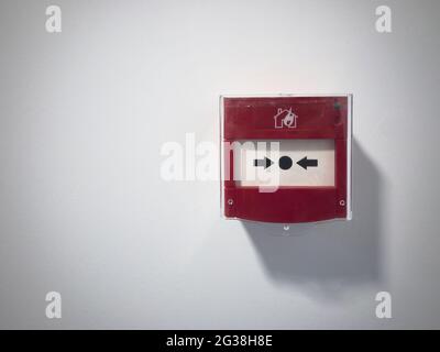 Red fire alarm button against blank white wall Stock Photo
