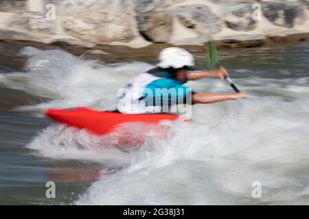 Kayaker in freestyle competition paddling through Class 2 rapids in Harvie Passage Whitewater Park on the Bow River, Calgary, Alberta, Canada Stock Photo