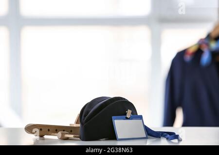 Stewardess hat with badge and plane figure on table indoors Stock Photo