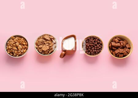 Bowls with different cereals and milk on color background Stock Photo