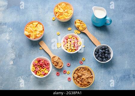 Different cereals, milk and blueberry on color background Stock Photo