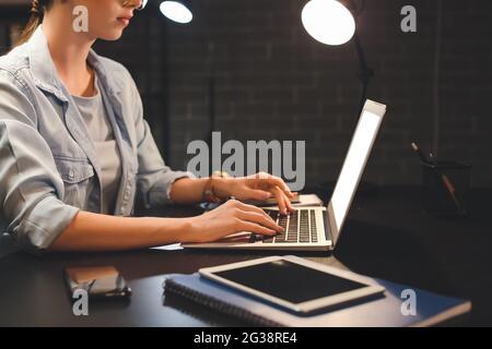 Young woman using laptop at home late in evening Stock Photo