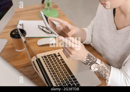 Female programmer using tablet computer in office, closeup Stock Photo