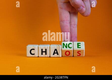 Chance or chaos symbol. Businessman turns wooden cubes and changes the word 'chaos' to 'chance'. Beautiful orange table, orange background, copy space Stock Photo