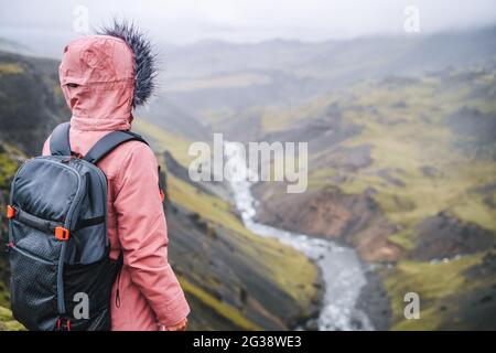 Close up of a woman with backpack enjoying icelandic highland and river fossa close to Haifoss waterfall in Iceland Stock Photo