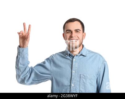 Handsome man showing victory gesture on white background Stock Photo