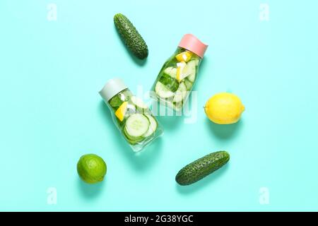 Bottles with cucumber lemonade on color background Stock Photo