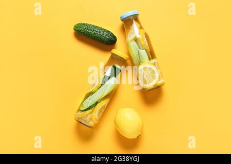 Bottles with cucumber lemonade on color background Stock Photo