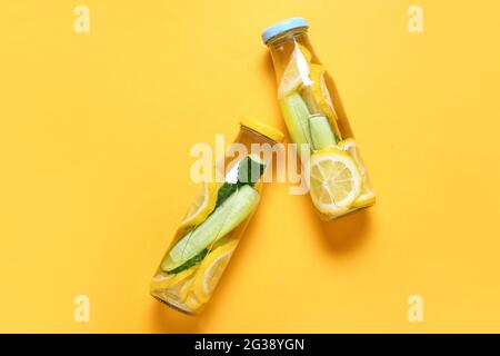 Bottles with cucumber lemonade on color background Stock Photo