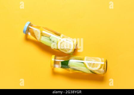 Bottles with cucumber lemonade on color background Stock Photo