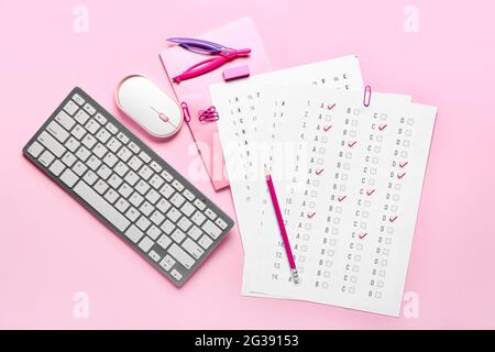 Answer sheets, stationery, computer keyboard and mouse on color background Stock Photo
