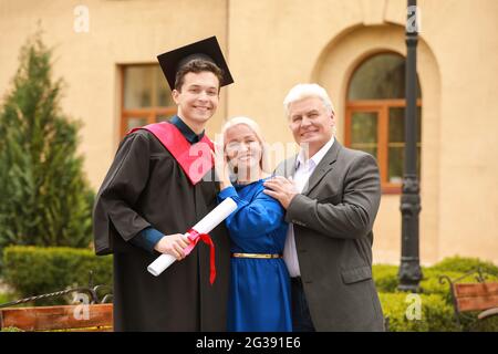 Happy young man with his parents on graduation day Stock Photo
