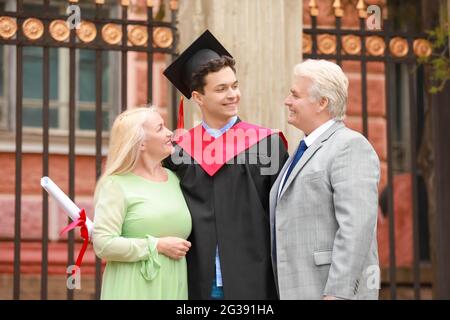 Happy young man with his parents on graduation day Stock Photo