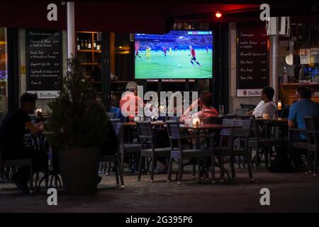 Berlin, Germany. 14th June, 2021. In the outdoor area of a restaurant, guests are watching the European Championship group E match between Spain and Sweden. Credit: Kira Hofmann/dpa-Zentralbild/dpa/Alamy Live News Stock Photo