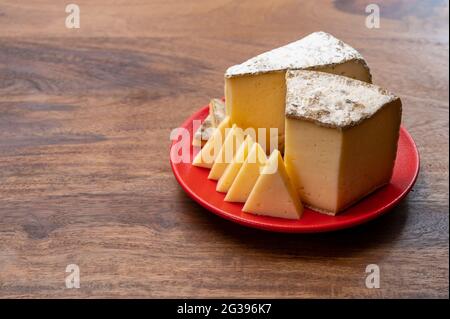 Cheese collection, Tomme de Savoie cheese from Savoy region in French Alps,  mild cow's milk cheese with beige interior and thick brownish-grey rind c Stock Photo