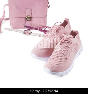 Layout on a white background. A small handbag, glasses, a watch and light summer shoes in pink and lilac colors. Stock Photo