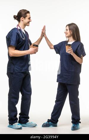 Portrait of two medical with coffee cups workers giving five isolated on a white background Stock Photo