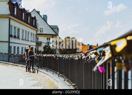 couple at the railing with many padlocks attached Stock Photo