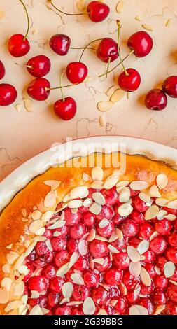 Cherry pie in a baking pan on the marble table. Cherries and almonds Stock Photo