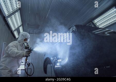 close up of paint spray gun, worker painting a car Stock Photo