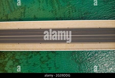 Aerial top view of a long bridge above a sea Stock Photo