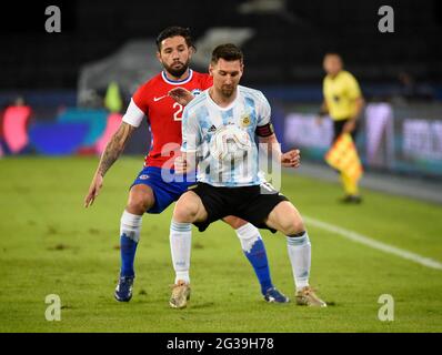 Rio De Janeiro, Brazil. 14th June, 2021. Argentina's Lionel Messi, front, and Chile's Eugenio Mena battle for the ball during a Copa America soccer match Credit: Andre Paes/Alamy Live News Stock Photo