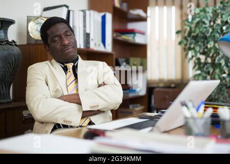 Tired businessman fell asleep at the desk in office Stock Photo