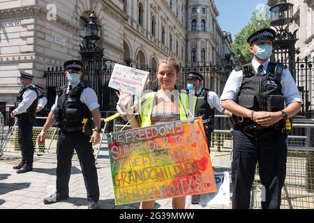 Anti-lockdown protestor holds a placard along Downing street in front of on-duty police officers during the demonstration.UK Prime Minister Boris Johnson is due to make an announcement regarding the extension of the lockdown regulations in the UK. Protestors gathered outside Downing Street at 12pm to protest against the extension, on the grounds that it is a violation of human rights and various freedoms. They also protested against wearing masks and being subjected to the vaccination program. (Photo by Belinda Jiao/SOPA Images/Sipa USA) Stock Photo