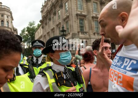 London, UK. 15th June, 2021. Police officers confront protestors outside Downing street during the demonstration.UK Prime Minister Boris Johnson is due to make an announcement regarding the extension of the lockdown regulations in the UK. Protestors gathered outside Downing Street at 12pm to protest against the extension, on the grounds that it is a violation of human rights and various freedoms. They also protested against wearing masks and being subjected to the vaccination program. Credit: SOPA Images Limited/Alamy Live News Stock Photo