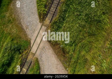 Wanzleben, Germany. 13th June, 2021. A railway track crosses an old cobbled path on a disused line. (Shot with a drone). Credit: Stephan Schulz/dpa-Zentralbild/ZB/dpa/Alamy Live News Stock Photo