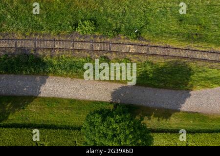 Wanzleben, Germany. 13th June, 2021. An old railway track runs past freshly tilled fields. (Shot with a drone) Credit: Stephan Schulz/dpa-Zentralbild/ZB/dpa/Alamy Live News Stock Photo