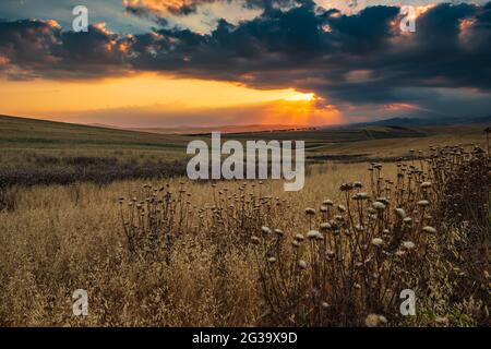 Dramatic sunset over farm fields Stock Photo