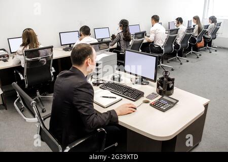 office workers at work on computers in the workplace. Stock Photo
