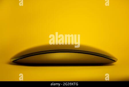 Modern tech wireless computer mouse on a yellow background Stock Photo