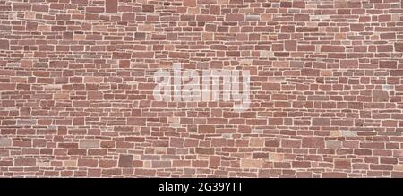 Wall made of many small stones of red sandstone Stock Photo