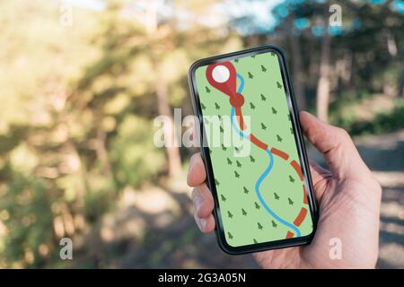 Traveler uses a navigator on his cell phone in the forest. Stock Photo